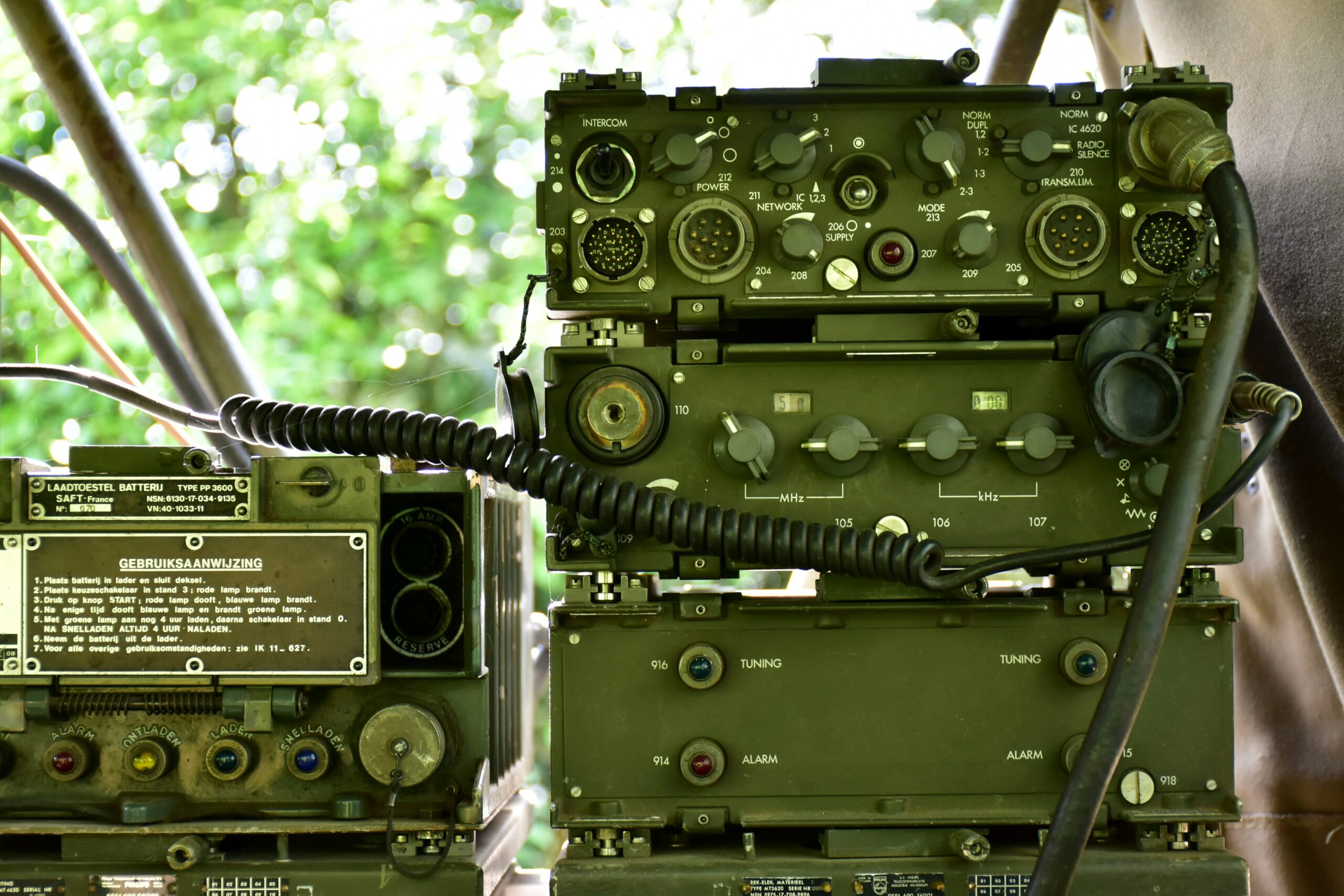 a couple of military radio equipment sitting on top of a wooden table