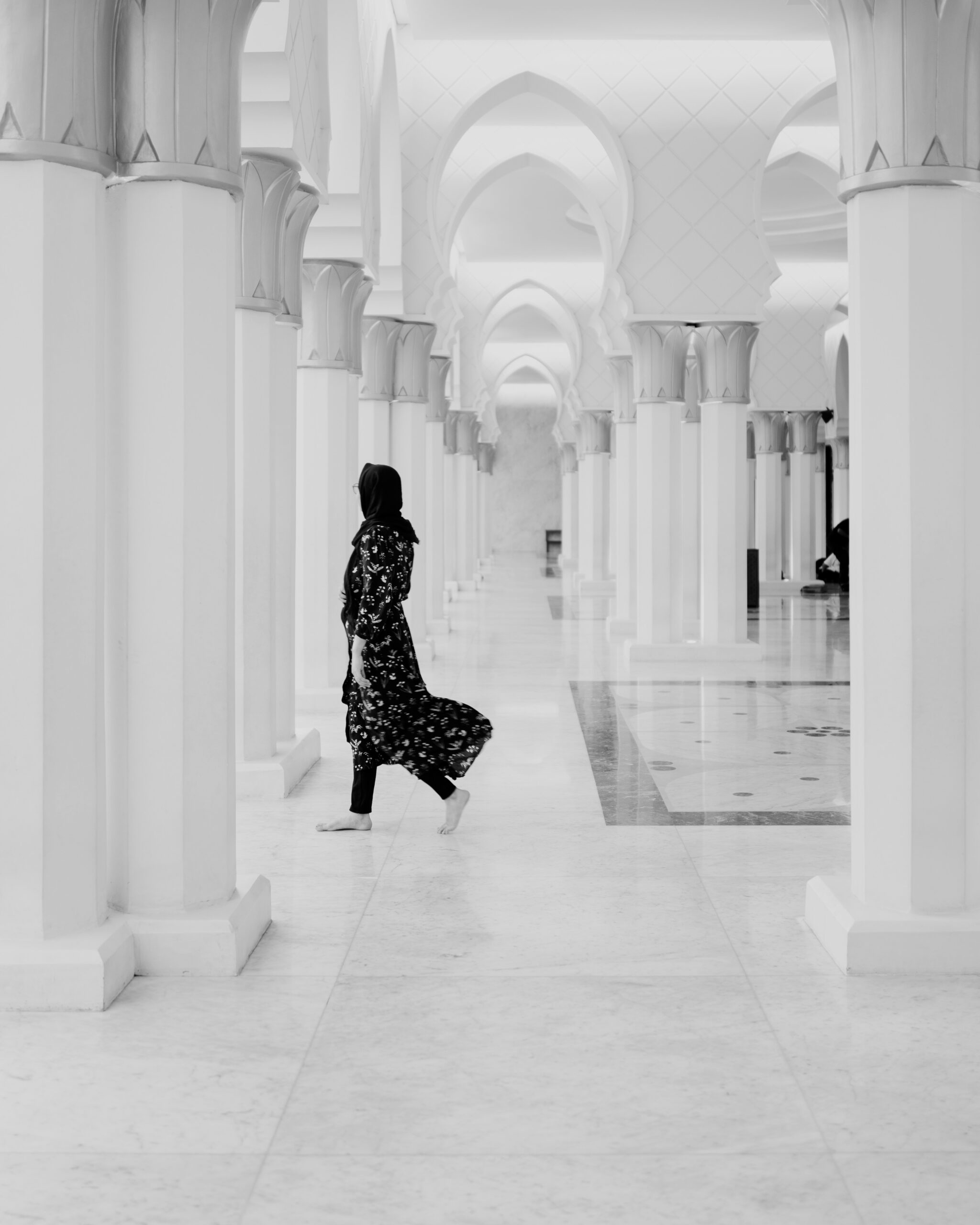 A woman in a long dress walking down a hallway