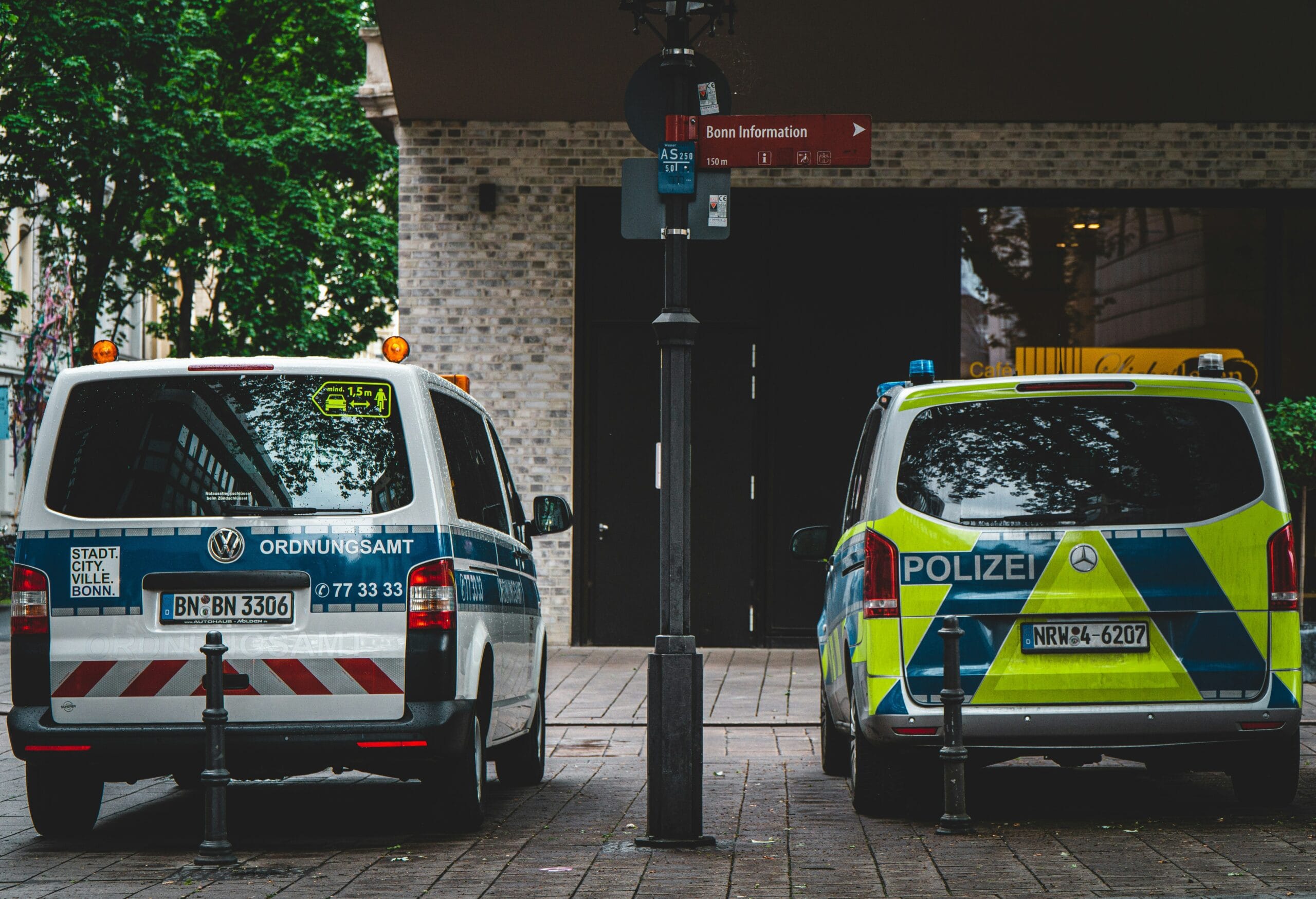 white and yellow police car parked beside brown brick building during daytime