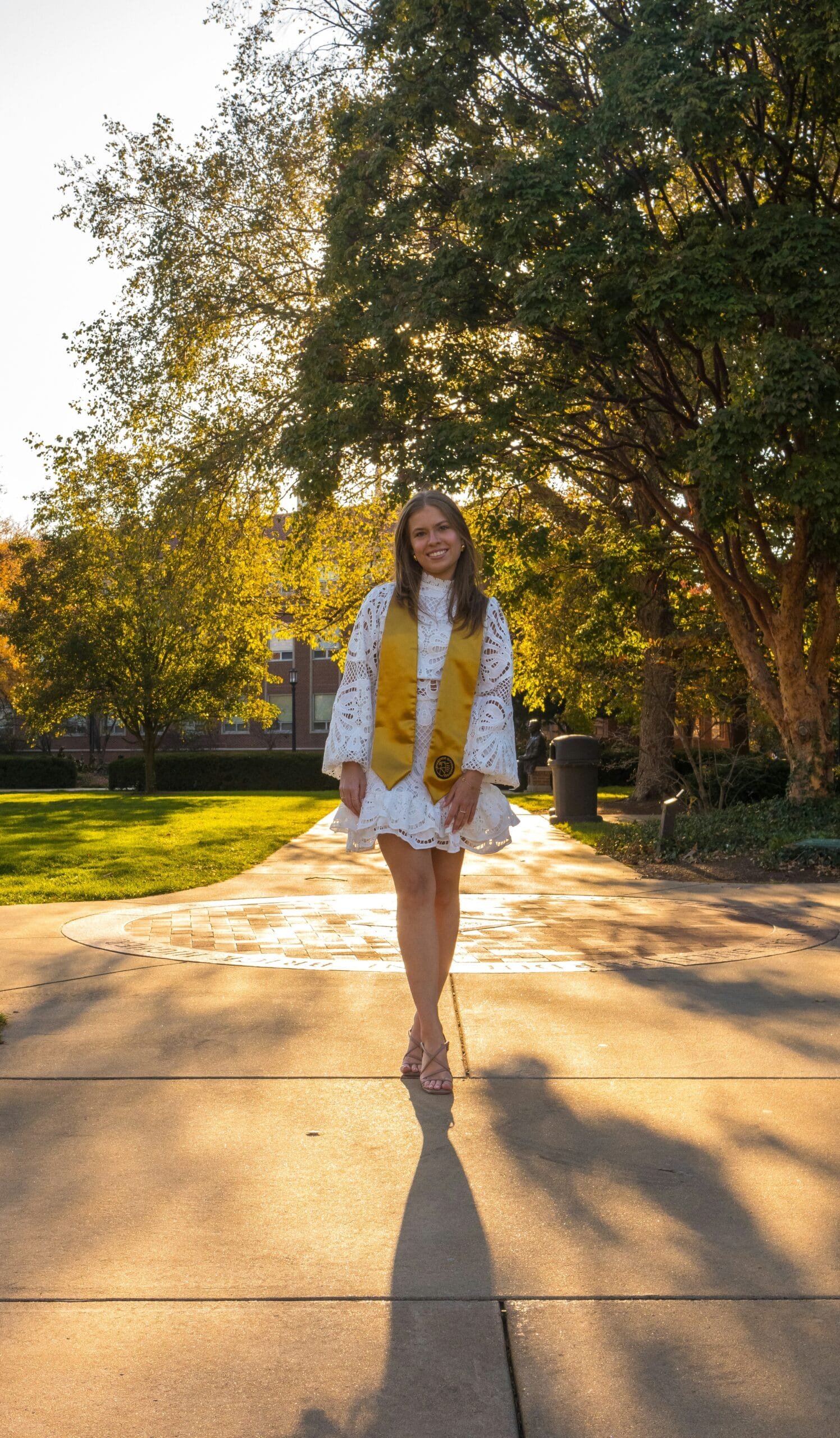 A woman in a white dress and yellow scarf