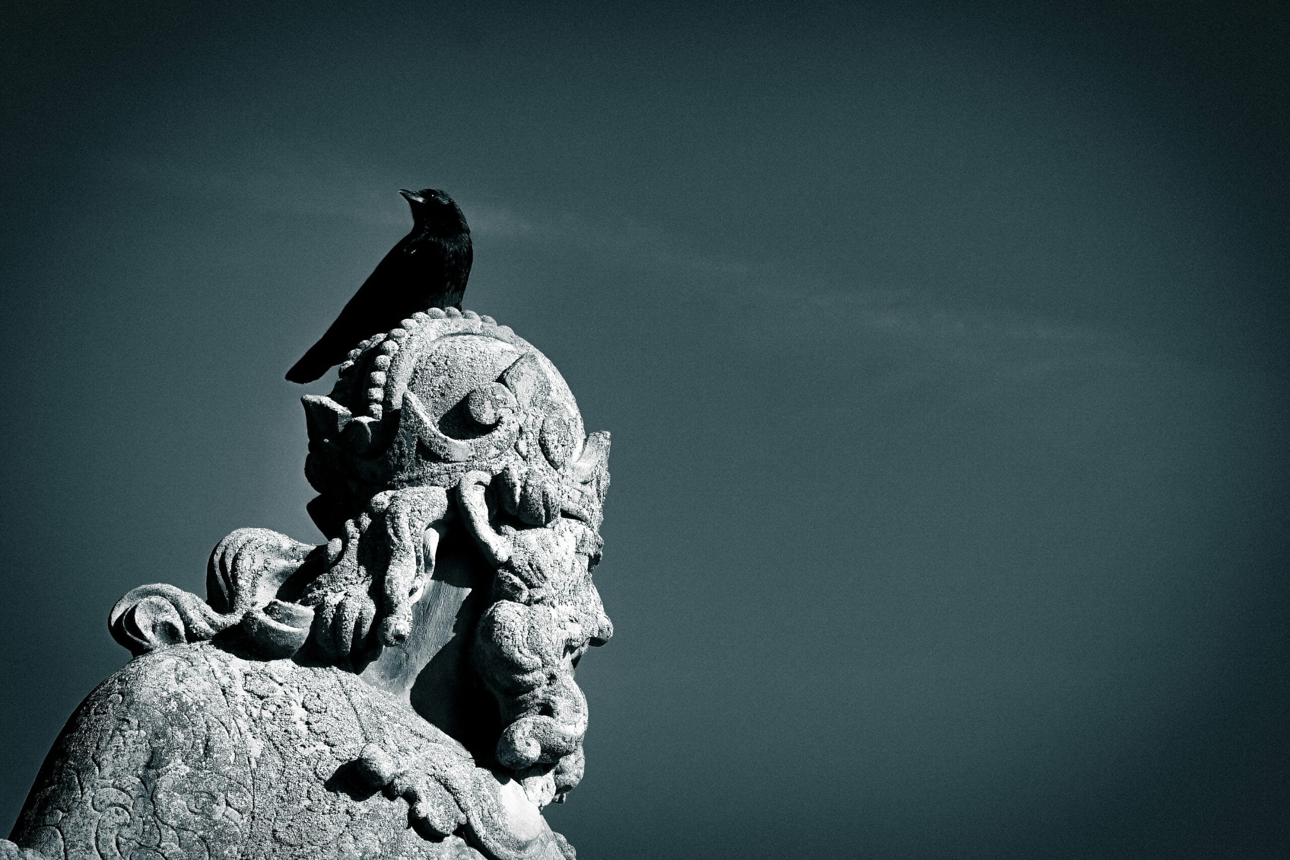 a bird is perched on top of a statue