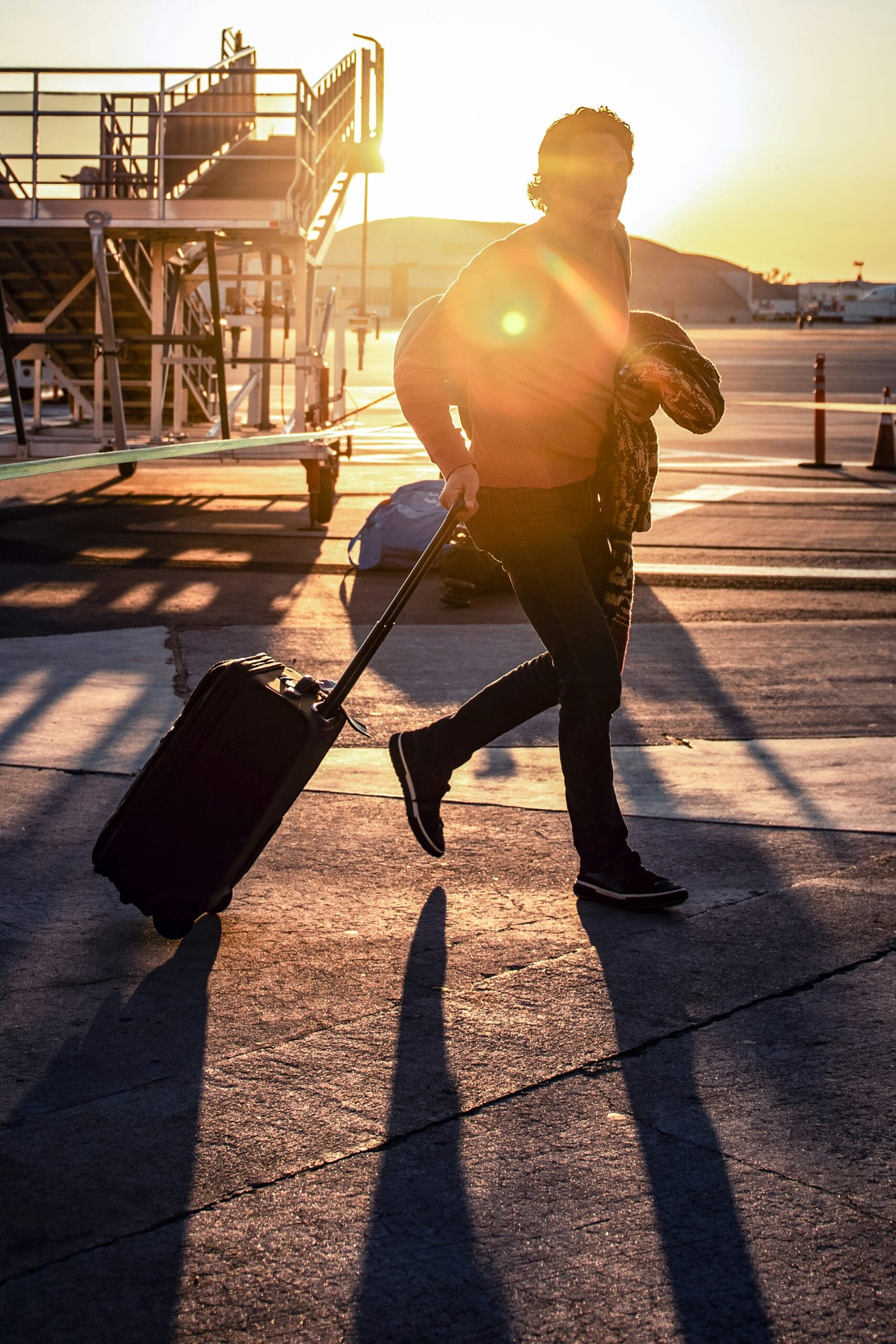 man walking with his black luggage bag